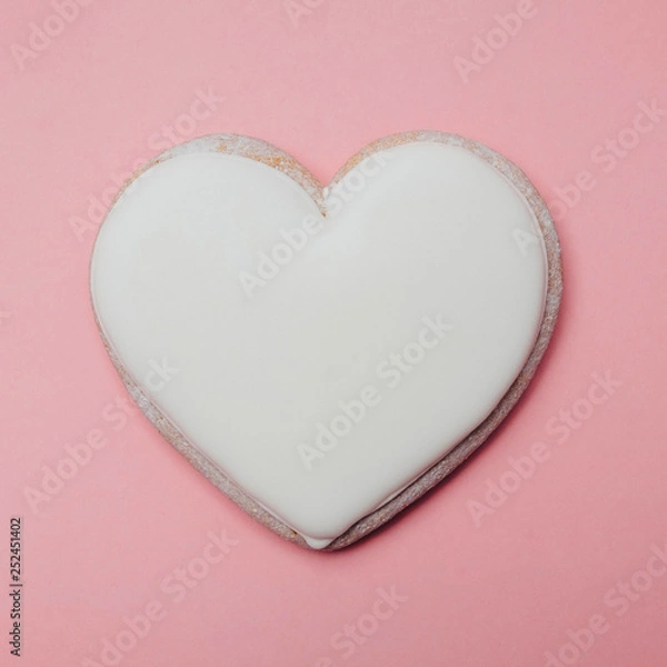 Obraz Heart shaped white cookie on a pink background. Love or like concept. Minimal food. Square image.