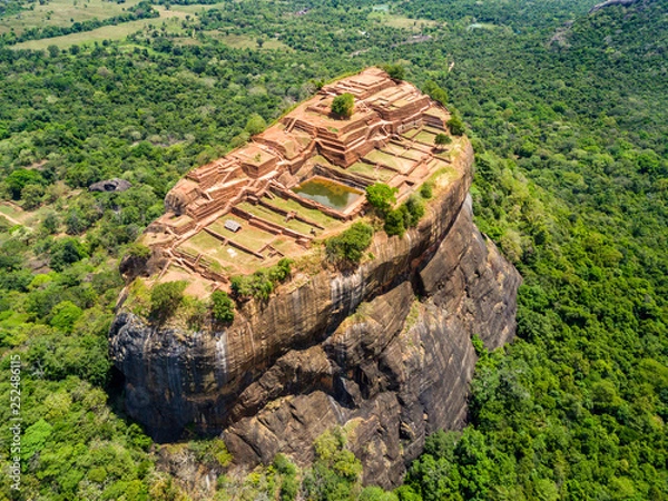 Fototapeta Aerial view from above of Sigiriya or the Lion Rock, an ancient fortress and a palace with gardens, pools, and terraces atop of granite rock in Dambulla, Sri Lanka. Surrounding jungles and landscape