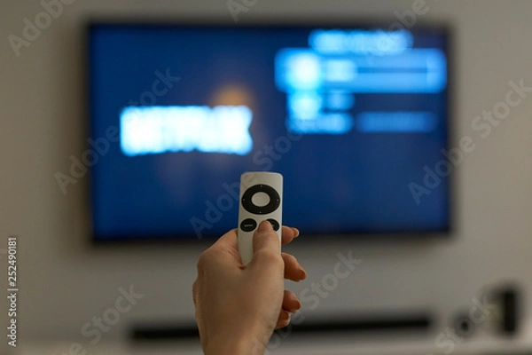 Obraz Holding hand on remote control