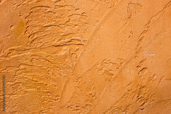 Fototapeta Close-up of colorful golden bronze plastered uneven stucco wall. Abstract texture, chaotic copy space background. Decorative grunge space.