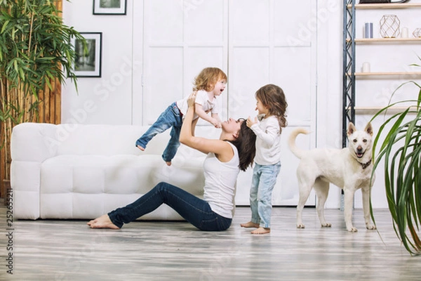 Obraz Małe dziewczynki są piękne i urocze z matką i psem w domu razem szczęśliwe