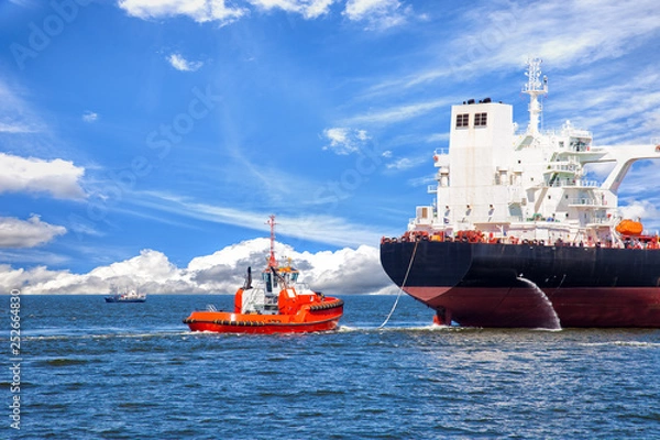 Fototapeta Tanker ship with escorting tug leaving port.