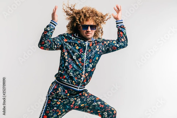 Obraz Podekscytowany zabawny dorosły człowiek w stylowe ubrania vintage, pozowanie na tle białego studia. Moda z lat 80. Funky facet w dresie i okularach przeciwsłonecznych wyrazisty niezwykły portret w pomieszczeniu. Krzyczący wesoły mężczyzna.