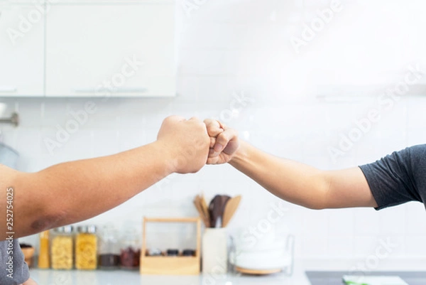 Fototapeta Fat man and trainer bumping fists on kitchen room, trainer and fat man giving fist bumping