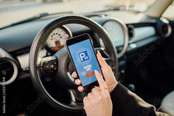 Fototapeta Girl using smartphone app to pay for the parking.