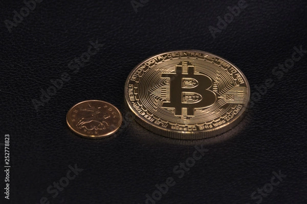 Fototapeta a small coin near a large coin bitcoin on black leather