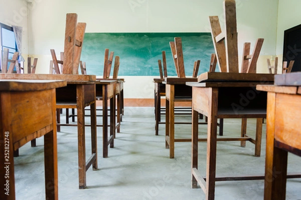 Fototapeta chair and table in class room with black board background, no student, school closed concept