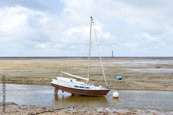 Fototapeta Sailing boat beached on the sand with horizon in the background