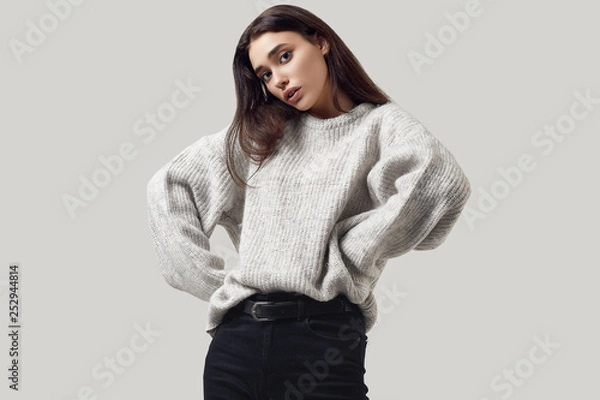 Obraz Beautiful brunette woman in sweater posing in studio