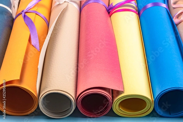 Fototapeta background of colorful leather rolls tied with a ribbon