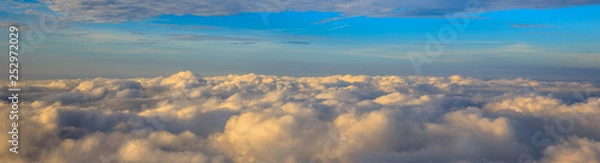 Fototapeta Abstract photograph above the clouds, sea of clouds effect, flying through the sky, aerial view, white puffy clouds and blue sky. Low pressure front atmospheric effect, cloudscape, clear weather.