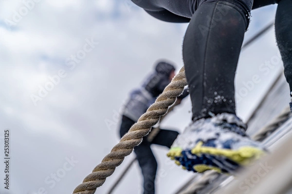 Fototapeta A man climbs an obstacle at a sporting event