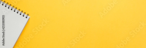 Obraz Yellow empty background with space for text. Copy space. Creative concept desk. Top view. Opened notebook. Panorama