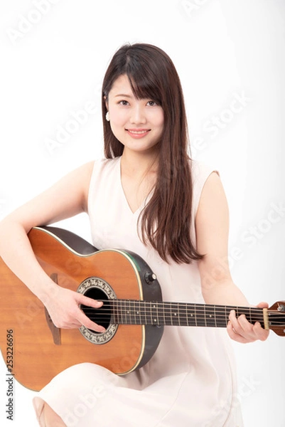 Fototapeta ギターを笑顔で弾く女性