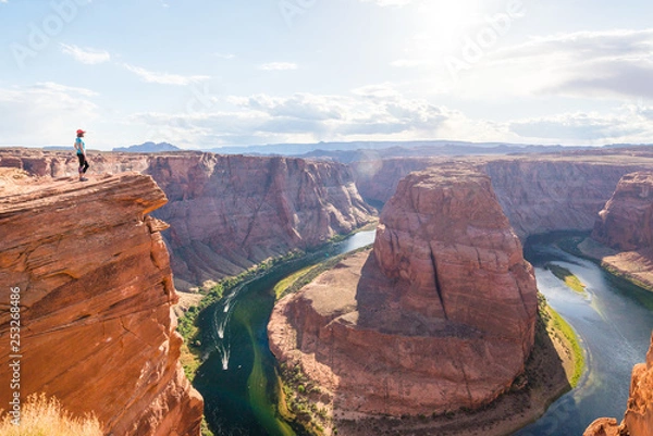 Fototapeta Woman Stands Over the Edge of Horseshoe Bend. Young woman enjoying view of Horseshoe bend, Arizona. Travel and adventure concept.