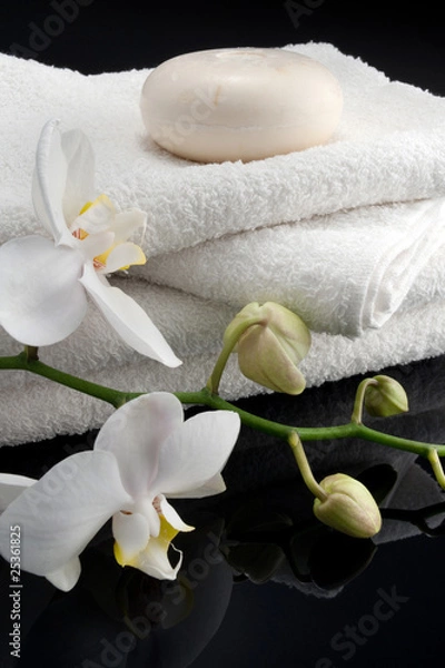 Fototapeta round soap on square white towels, black bacground