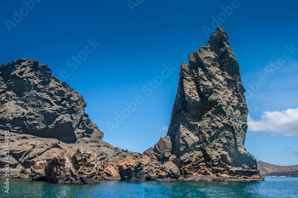 Fototapeta Galapagos Islands. Ecuador. Bartolome Island. Pinnacle Rock. Rocks in the water. Rocks of frozen volcanic lava. Ecuador. Travel to Ecuador.