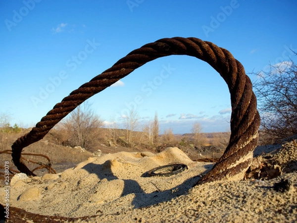 Fototapeta thick rusty wire rope and ring in sand