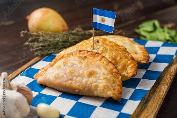 Fototapeta Argentinian empanadas with flag on a dark rustic wooden background