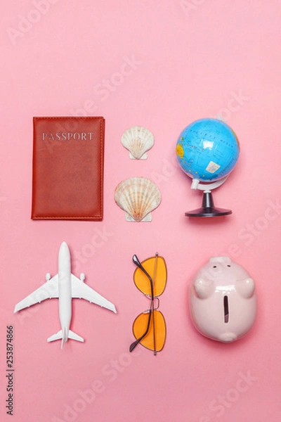 Fototapeta Vacation travel summer weekend sea adventure trip concept. Minimal simple flat lay with plane passport sunglasses globe piggy bank and shell on pink pastel trendy modern background. Tourist essentials