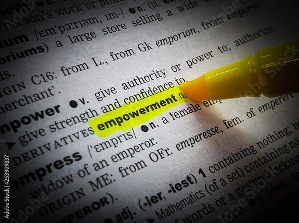 Fototapeta A close up of the word:  empowerment,in a dictionary, highlighted in yellow and showing part of its definition.