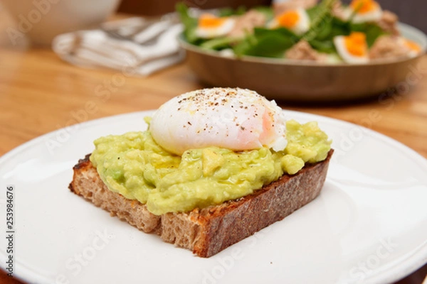 Fototapeta Puached egg, avocado and grilled bread