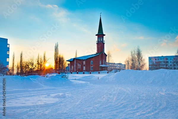 Fototapeta A small mosque of red brick. Winter. Sunset