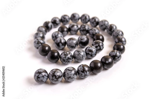 Obraz Snowflake obsidian beads on white background
