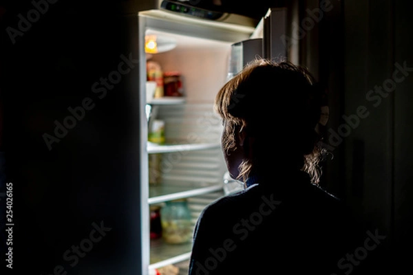 Obraz woman by the open refrigerator at night