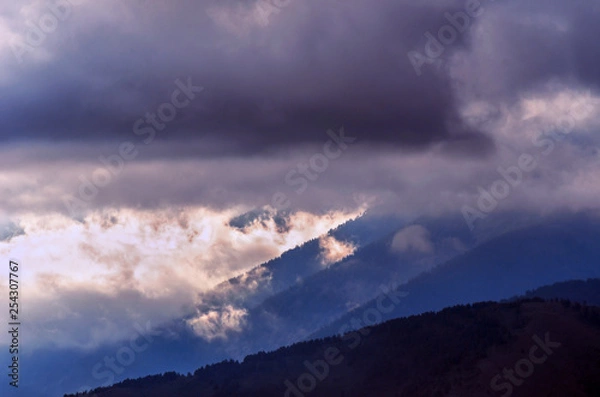 Fototapeta Dramatic Sunrise in the Mountains with Cloudy Sky and Misty Forest, Altai Mountains, East Kazakhstan. Fantasyland, Blue Hour Concept.