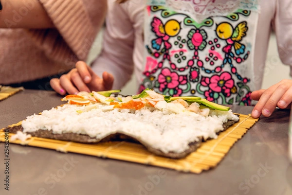 Fototapeta A child making sushi