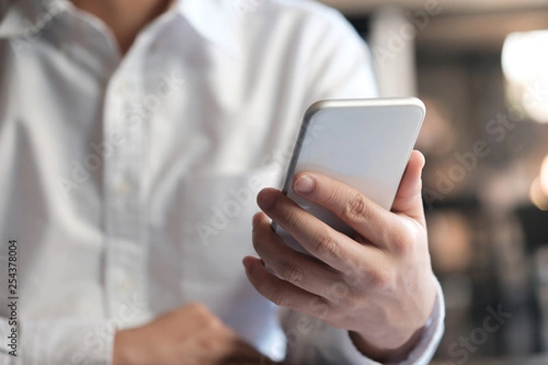 Fototapeta Business man hand hold smart phone. technology concept