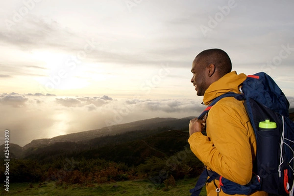 Fototapeta happy african american hiker looking at view from mountain