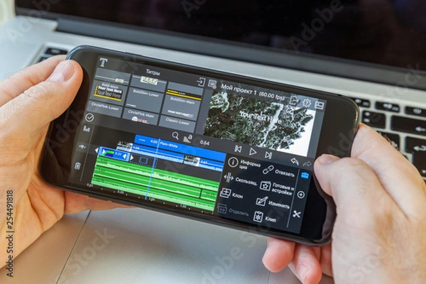 Obraz Black smartphone in hand. On-screen video editing program