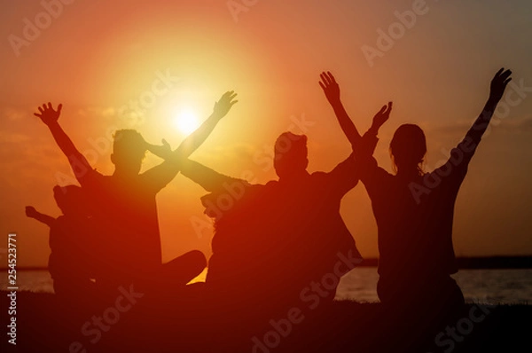 Obraz Group of teenagers and child feeling free at sunset