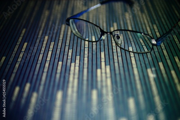 Fototapeta big data analysis. glasses placed on a LED digital panel display white light one and zero binary text number in moving motion pattern. modern technology blue block grid pattern backgrounds