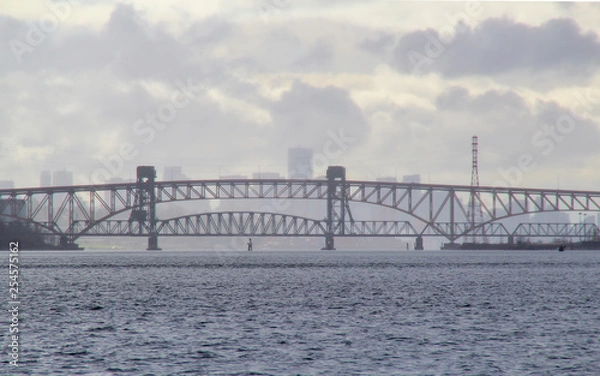 Obraz 안개속 철교 너머로 흐릿하게 보이는 도시의 실루엣