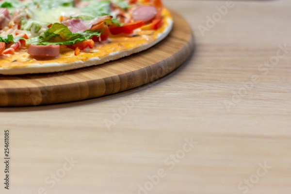 Obraz Side view homemade pizza with copy space on bright background with selective soft focus.