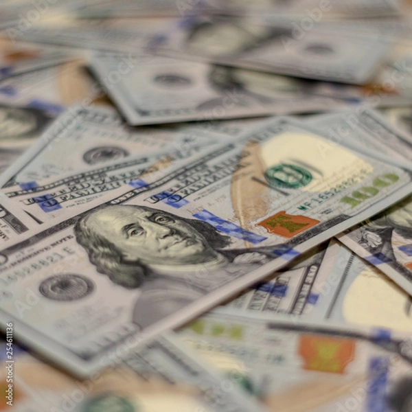 Obraz Macro shot of Benjamin Franklin's portrait on a new 100 dollar US money note, with defocused background of many more identical money notes in a mess.