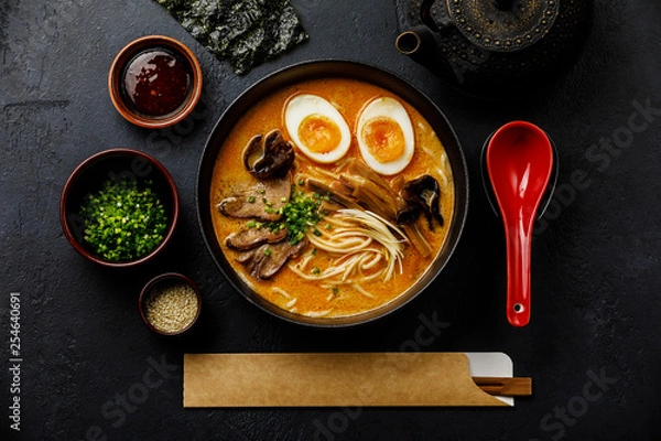 Fototapeta Ramen azjatycki makaron w bulionie z mięsem wołowym, grzybami i marynowanym jajkiem Ajitama w misce na ciemnym tle