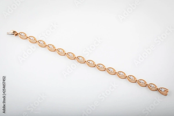 Fototapeta Women's golden bracelet with stone inserts isolated on white background