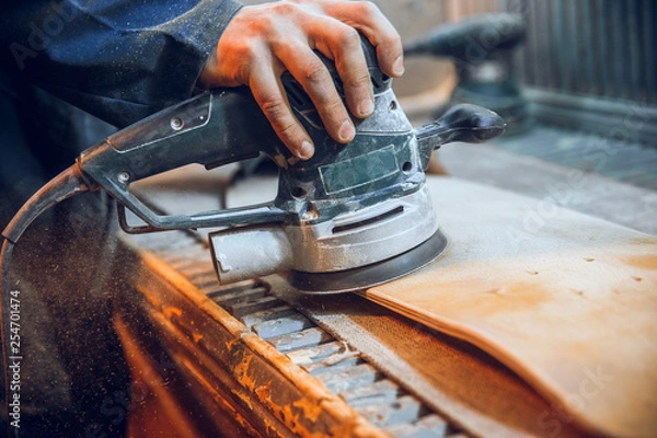 Fototapeta Carpenter using circular saw for cutting wooden boards. Construction details of male worker or handy man with power tools