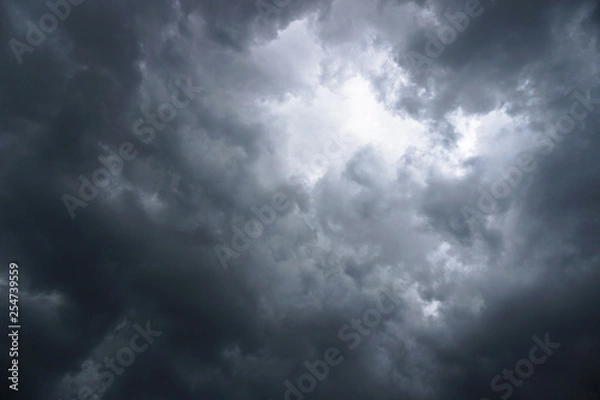 Fototapeta Dark, grim, stormy, rainy sky with rays of light. Scary hurricane clouds. Natural element. Stock Photo for your design
