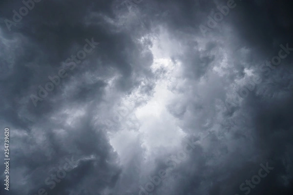Fototapeta Dark, grim, stormy, rainy sky with rays of light. Scary hurricane clouds. Natural element. Stock Photo for your design