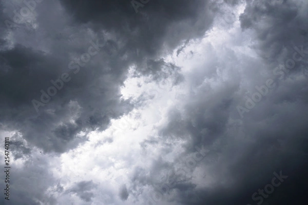 Fototapeta Dark, grim, stormy, rainy sky with rays of light. Scary hurricane clouds. Natural element. Stock Photo for your design