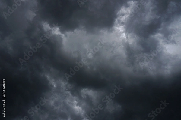 Fototapeta Dark, grim, stormy, rainy sky with rays of light. Scary hurricane clouds. Natural element. Stock Photo for your design