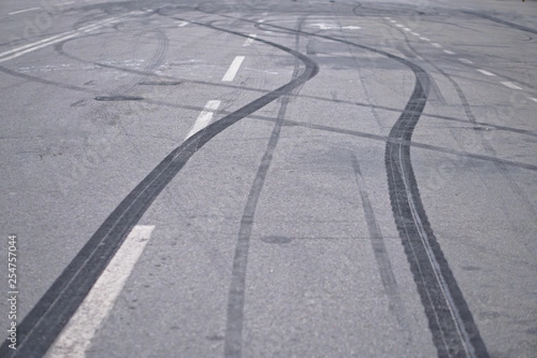 Fototapeta Abstract of Black tire wheels caused by Drift car on the road. Braking at a pedestrian crossing and a road with markings. Stock photo for design