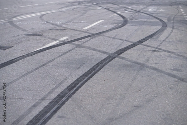 Fototapeta Abstract of Black tire wheels caused by Drift car on the road. Braking at a pedestrian crossing and a road with markings. Stock photo for design