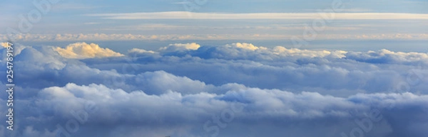 Fototapeta Abstract photograph above the clouds, sea of clouds effect, flying through the sky, aerial view, white puffy clouds and blue sky. Low pressure front atmospheric effect, cloudscape, clear weather