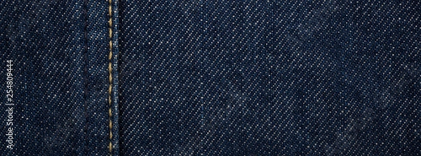 Obraz close up, macro shot of raw denim dark wash indigo blue jeans texture for banner background
